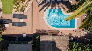 Vista aèria d'una zona de piscina amb gandules, una petita piscina i vegetació circumdant.