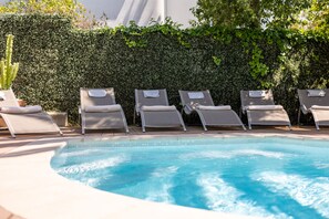 Una piscina al aire libre, tumbonas