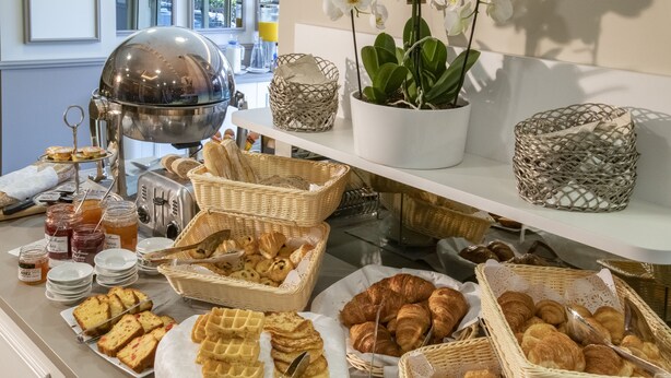 Un bufet amb diferents tipus de pa, pastissos i ingredients per acompanyar-los.