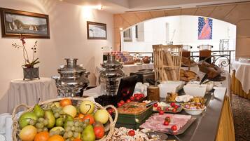 A buffet setup with various food items and a decorative archway in the background.