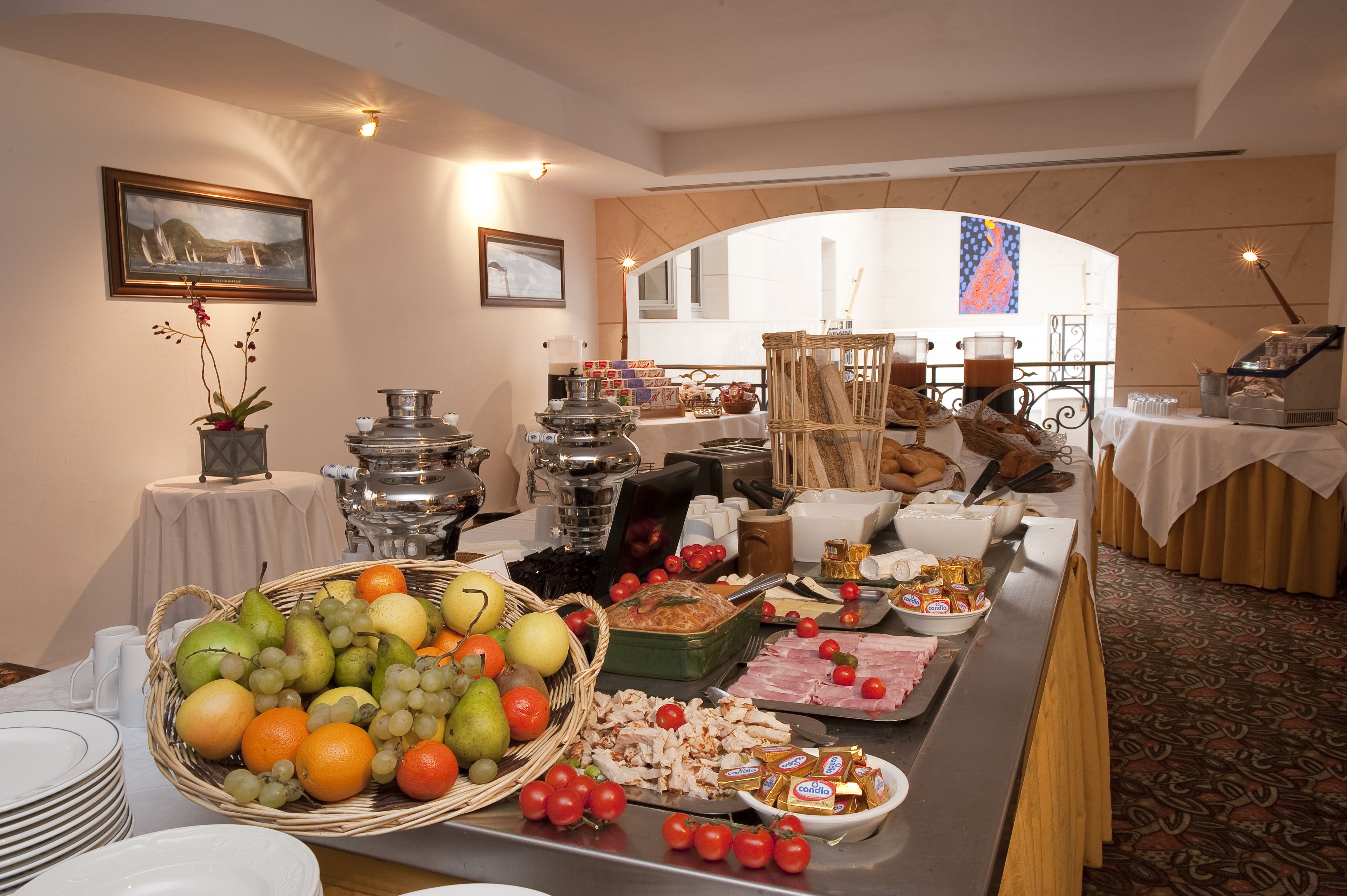 Montaje de bufé con diversos alimentos y una orquídea decorativa.
