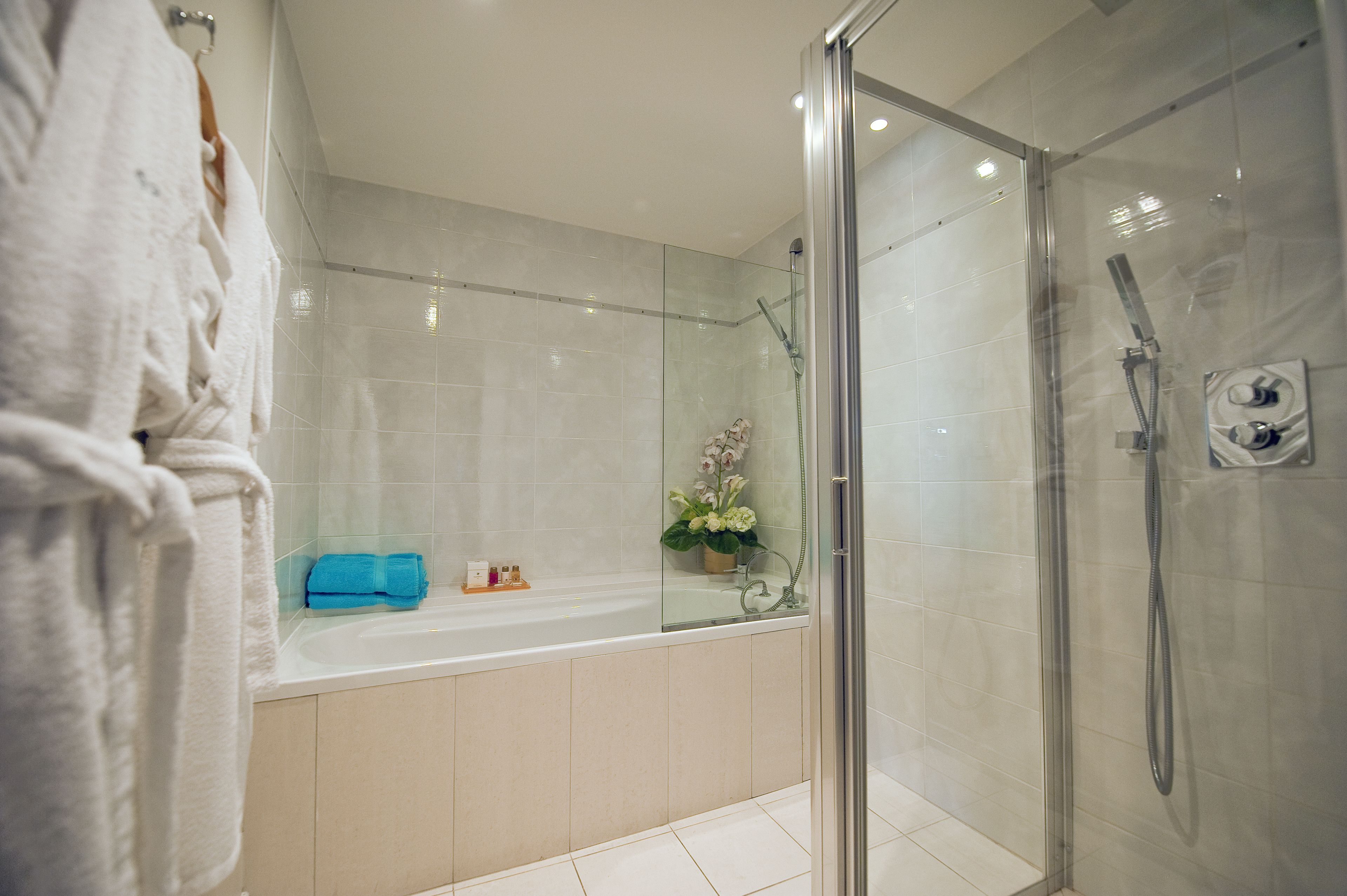 A modern bathroom with a glass-enclosed shower, a bathtub, and a vanity area.