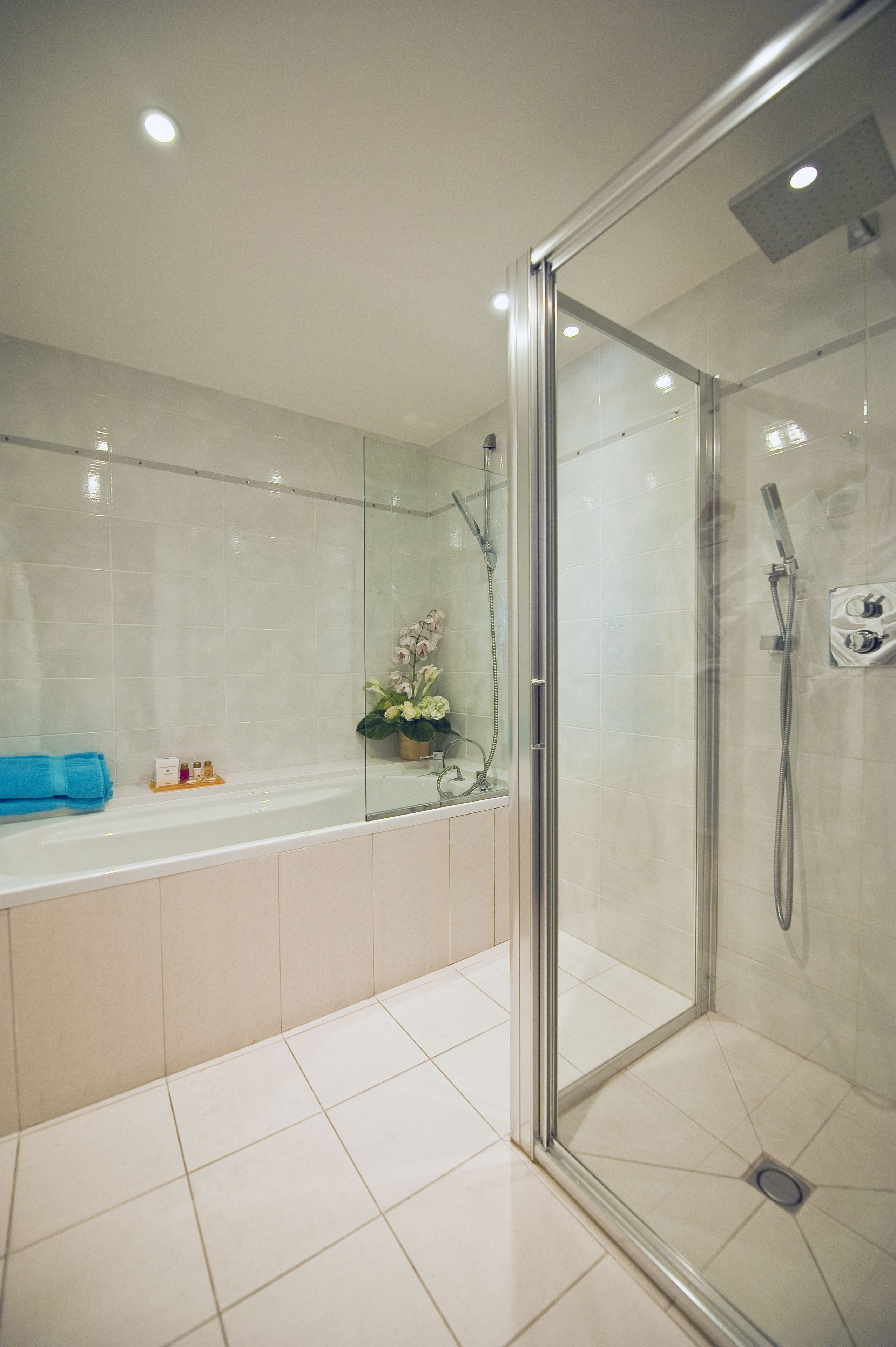 Un baño moderno con ducha de vidrio, bañera y un inodoro.