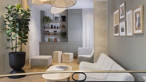 A modern living room with a large potted plant, a sofa, a coffee table, and a bookshelf. - Abbatial Saint Germain (Paris)