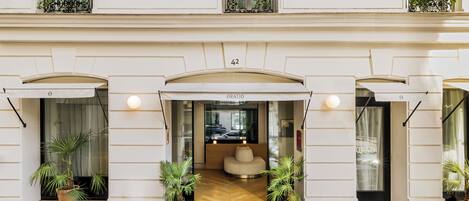A hotel entrance with a number 42 sign, a reception desk, and potted plants.