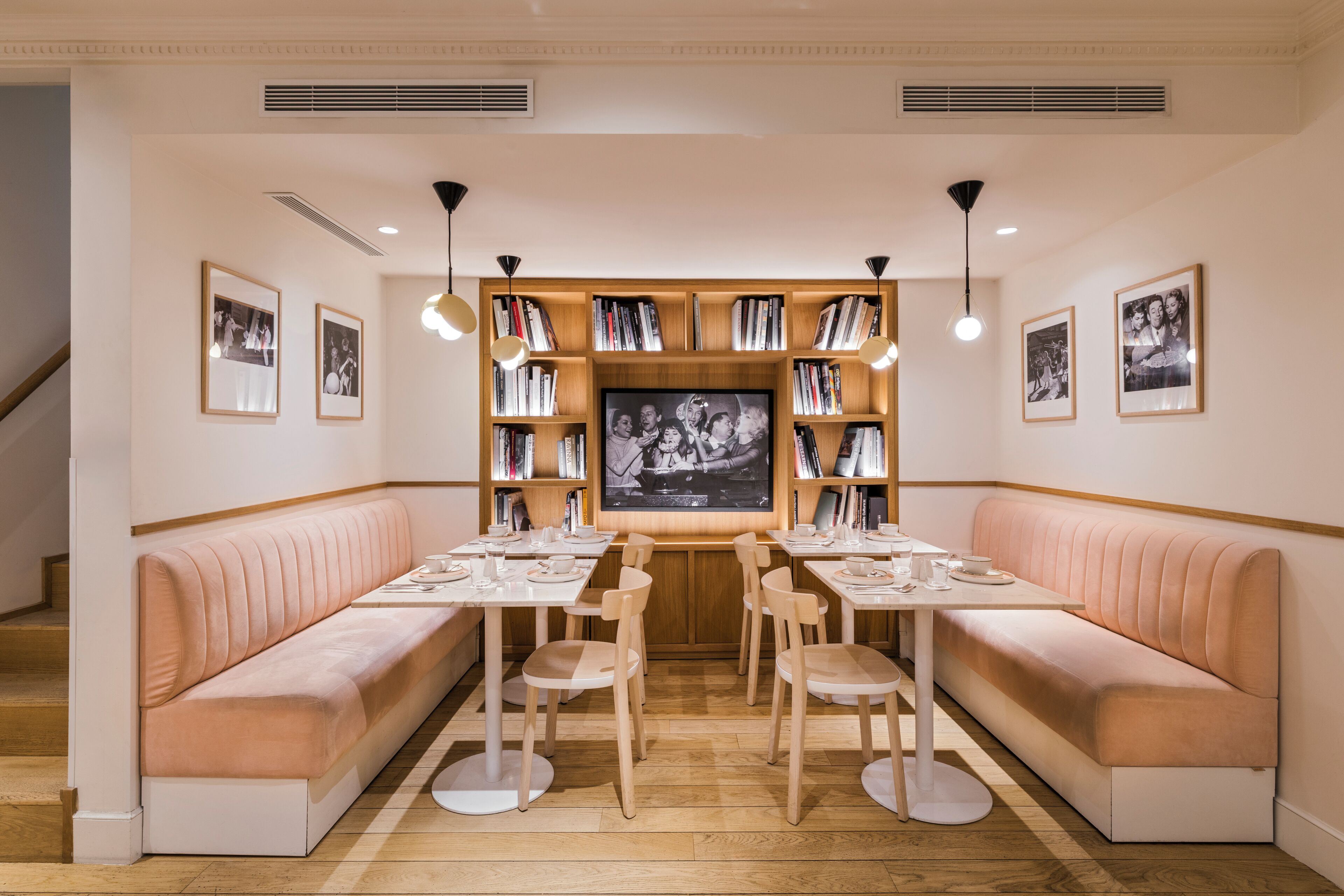 A dining area with a central table, two seating areas on either side, and a bookshelf with books and a framed photo.