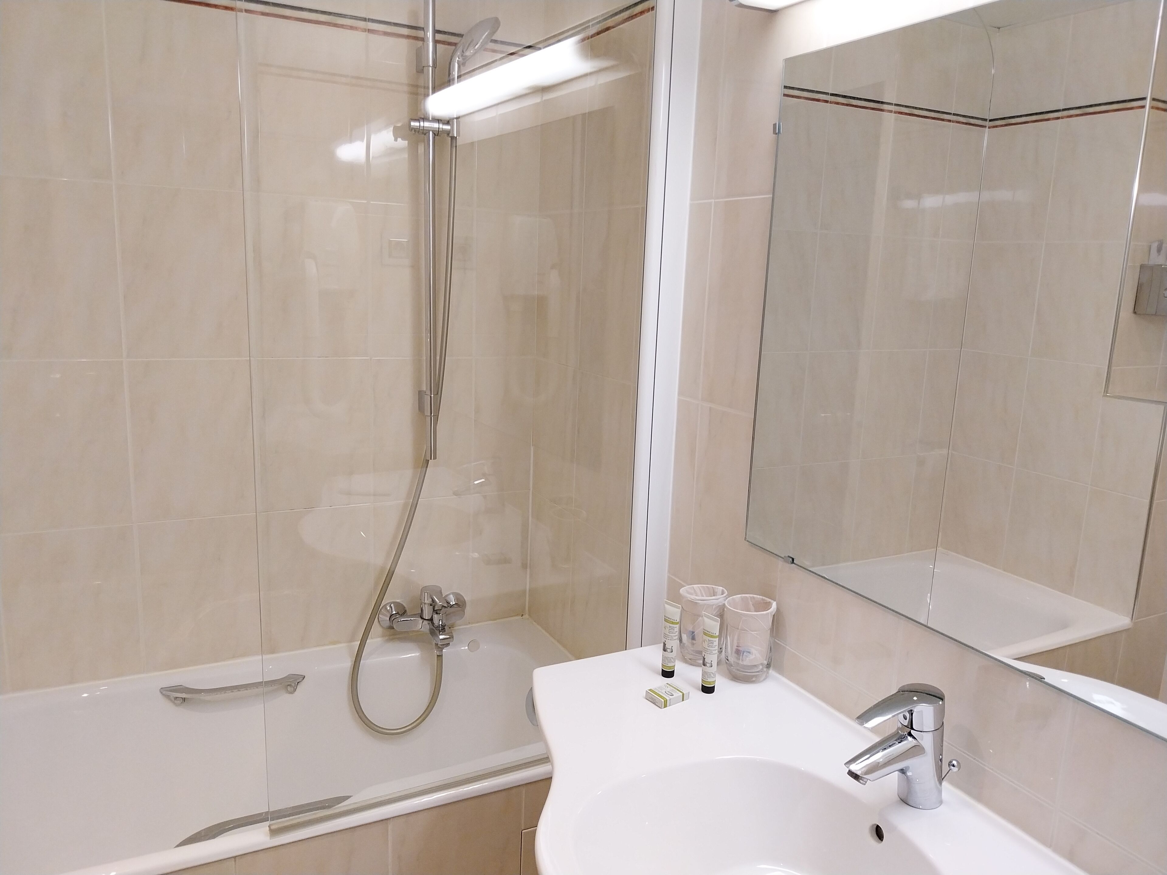 A modern bathroom with a bathtub, a shower, and a sink.