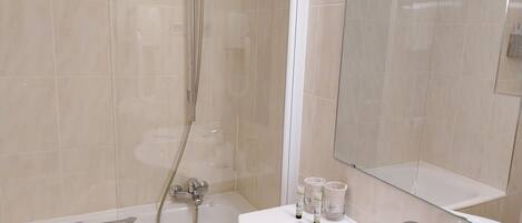 A modern bathroom with a bathtub, a shower, and a sink.