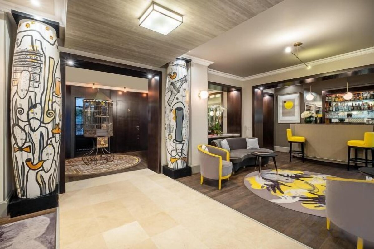 A lobby with a bar area, seating, and a patterned rug.