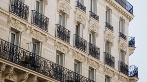 A multi-story building with ornate balconies and decorative architectural details. - Hotel Claude Bernard Saint Germain (Paris)