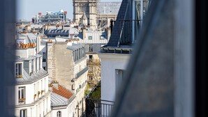 A view of Notre-Dame Cathedral with surrounding buildings and a clear sky. - Hotel Claude Bernard Saint Germain (Paris)