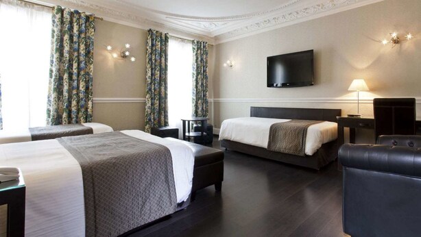 A hotel room with two beds, a flat-screen TV, a desk, and a chair. - Hotel Claude Bernard Saint Germain (Paris)