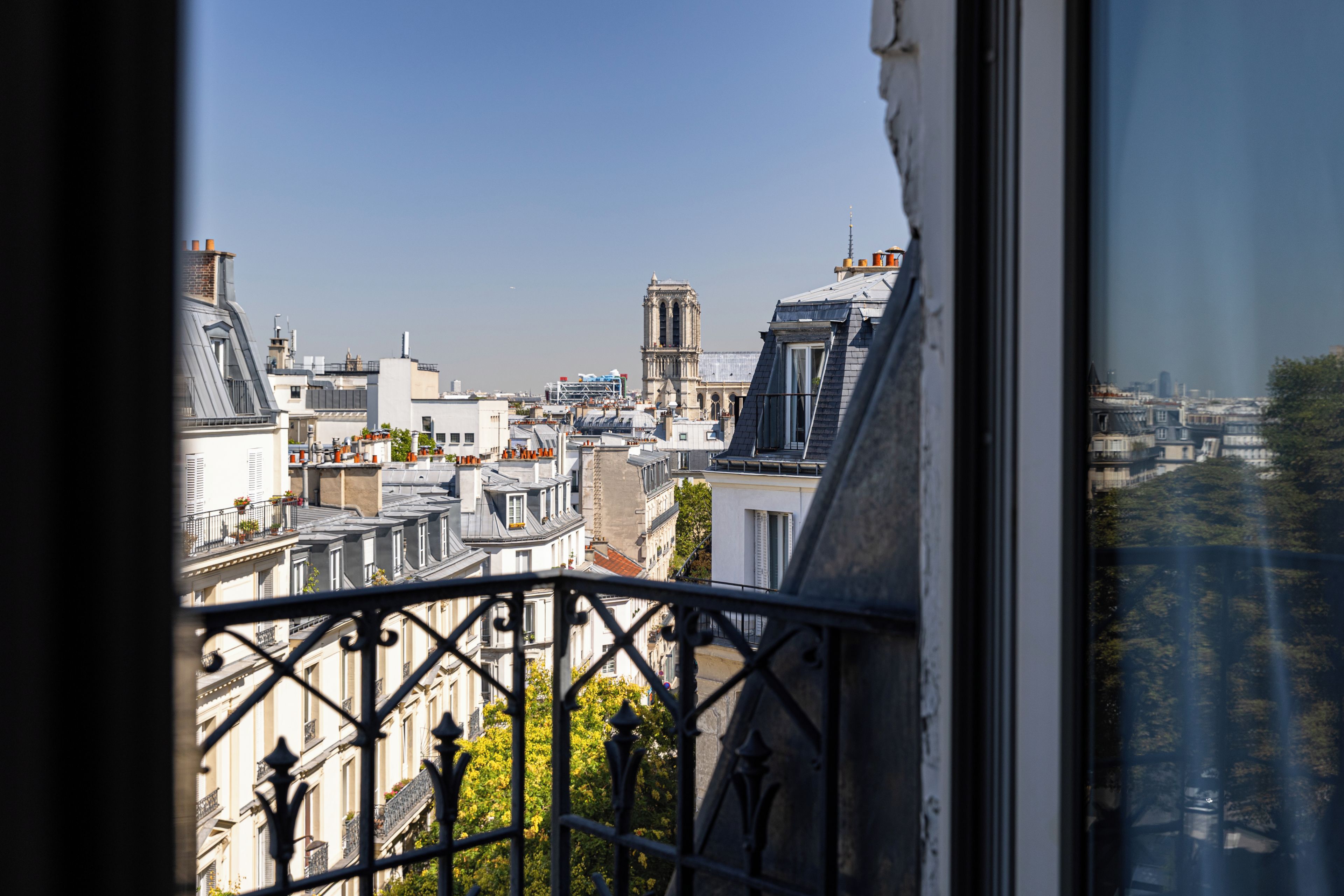 Vue sur les toits de Paris, avec la Tour Eiffel en arrière-plan.