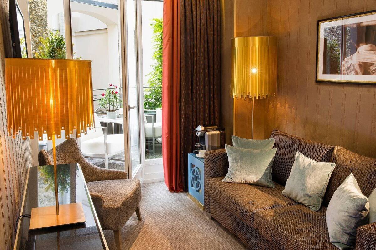A modern living room with a sofa, a chair, a table, and two floor lamps.