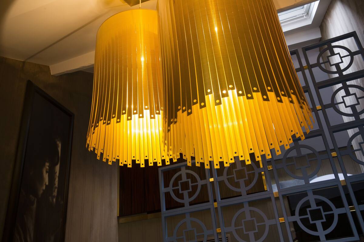 A modern interior with a unique yellow hanging light fixture and geometric wall design.