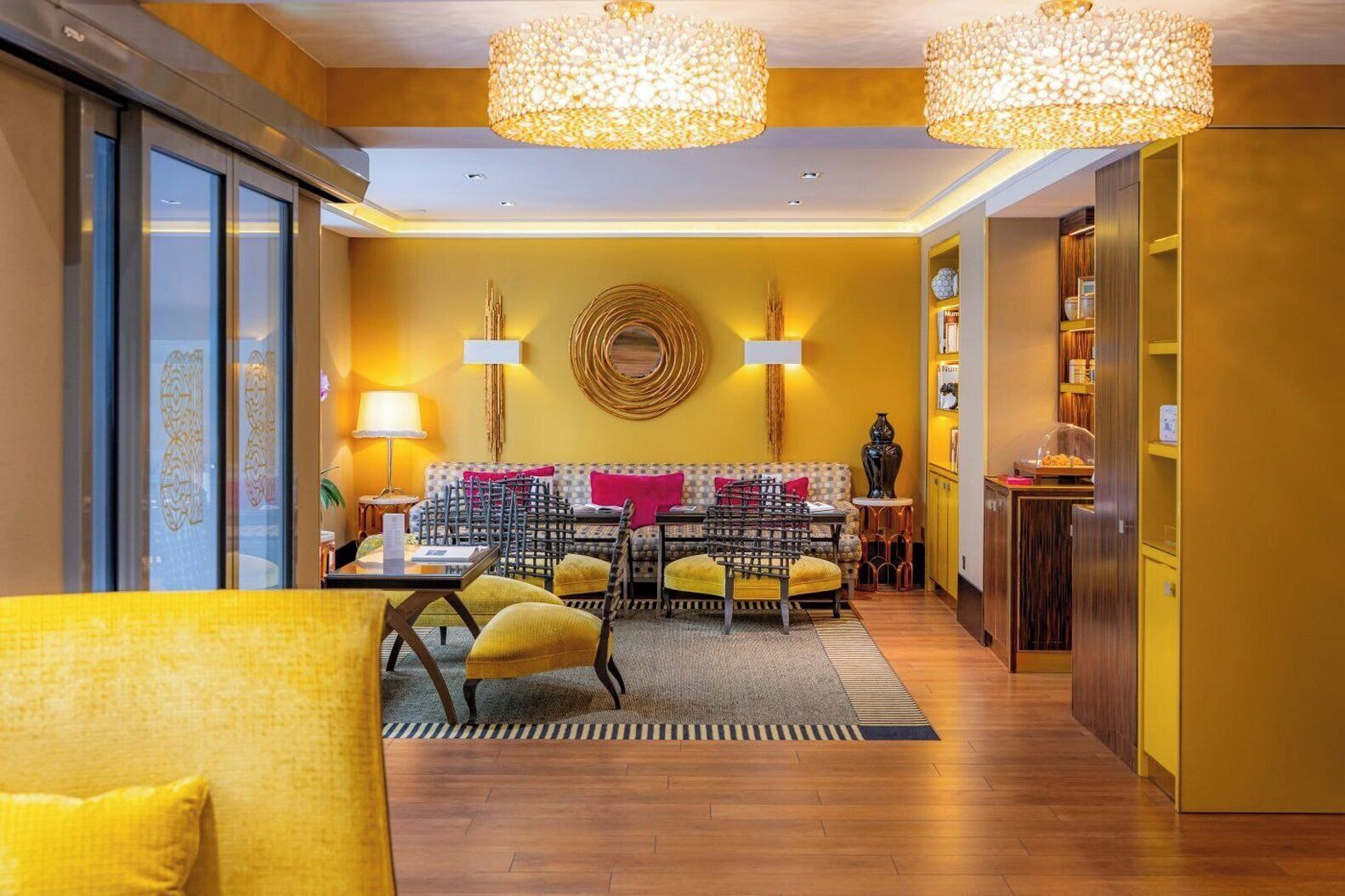 A modern interior with a dining area, yellow walls, and a chandelier.