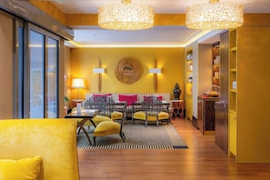 A modern interior with a dining area, yellow walls, and a chandelier. - Hôtel Baume (Paris)