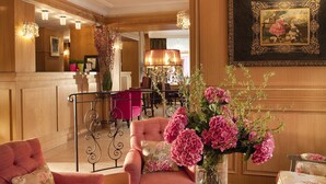 Un hall d’entrée bien éclairé, doté d’un espace salon, d’un coin repas et d’une grande œuvre d’art encadrée au mur.