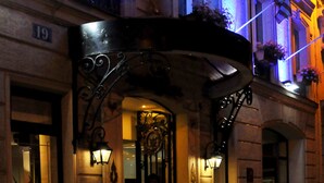 A hotel entrance with a sign reading "HOTEL AIDA MARAIS," ornate metalwork, and potted plants. - Hotel Aida Marais Printania (Paris)
