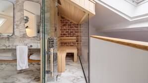 A modern bathroom with a marble floor, a wooden bench, a glass shower enclosure, and a skylight. - Hôtel Artus (Paris)