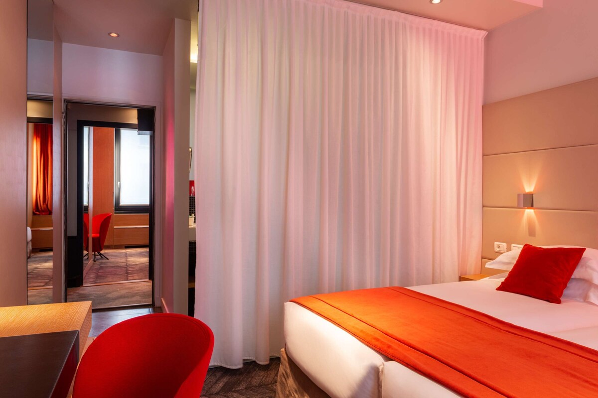 Una habitación de hotel con cama, escritorio y silla.