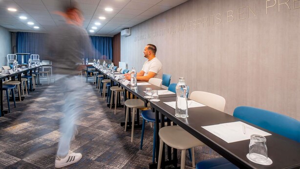 A conference room with tables, chairs, and an air conditioning unit on the wall.