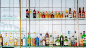 A bar area with shelves of various liquor bottles and glasses. - Mercure Paris Montparnasse Pasteur (Paris)