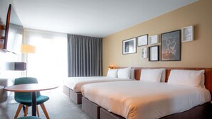 A hotel room with two beds, a small round table, a chair, and a lamp. - Mercure Paris Montparnasse Pasteur (Paris)