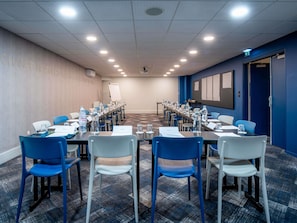 A conference room with a long table, chairs, water bottles, and a whiteboard. - Mercure Paris Montparnasse Pasteur (Paris)