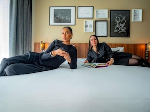 A hotel room with a bed, a nightstand, and framed technical drawings on the wall. - Mercure Paris Montparnasse Pasteur (Paris)