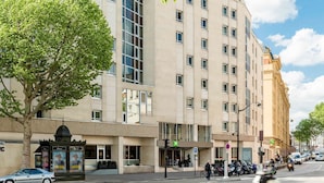 A multi-story hotel with a modern facade, large windows, and a ground-level entrance with a green sign. - ibis Styles Paris Gare de l'Est Château Landon (Paris)