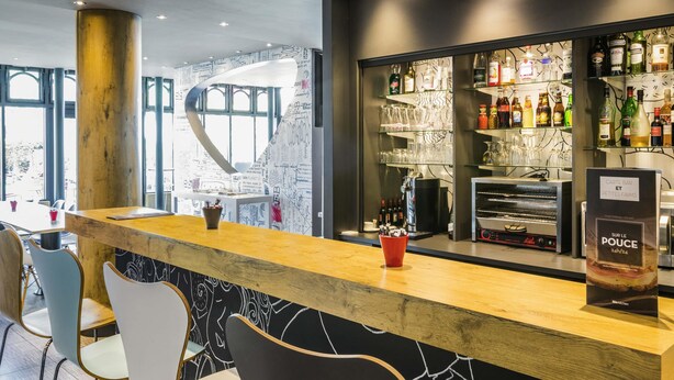 A bar area with a wooden counter, bar stools, and a wall with a chalkboard design. - ibis Paris Gare de Lyon Ledru Rollin 12ème (Paris)