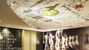 A modern lounge area with a curved ceiling decorated with various writings and drawings, a large chessboard mural, and a seating area with colorful chairs and tables. - ibis Paris Gare de Lyon Ledru Rollin 12ème (Paris)