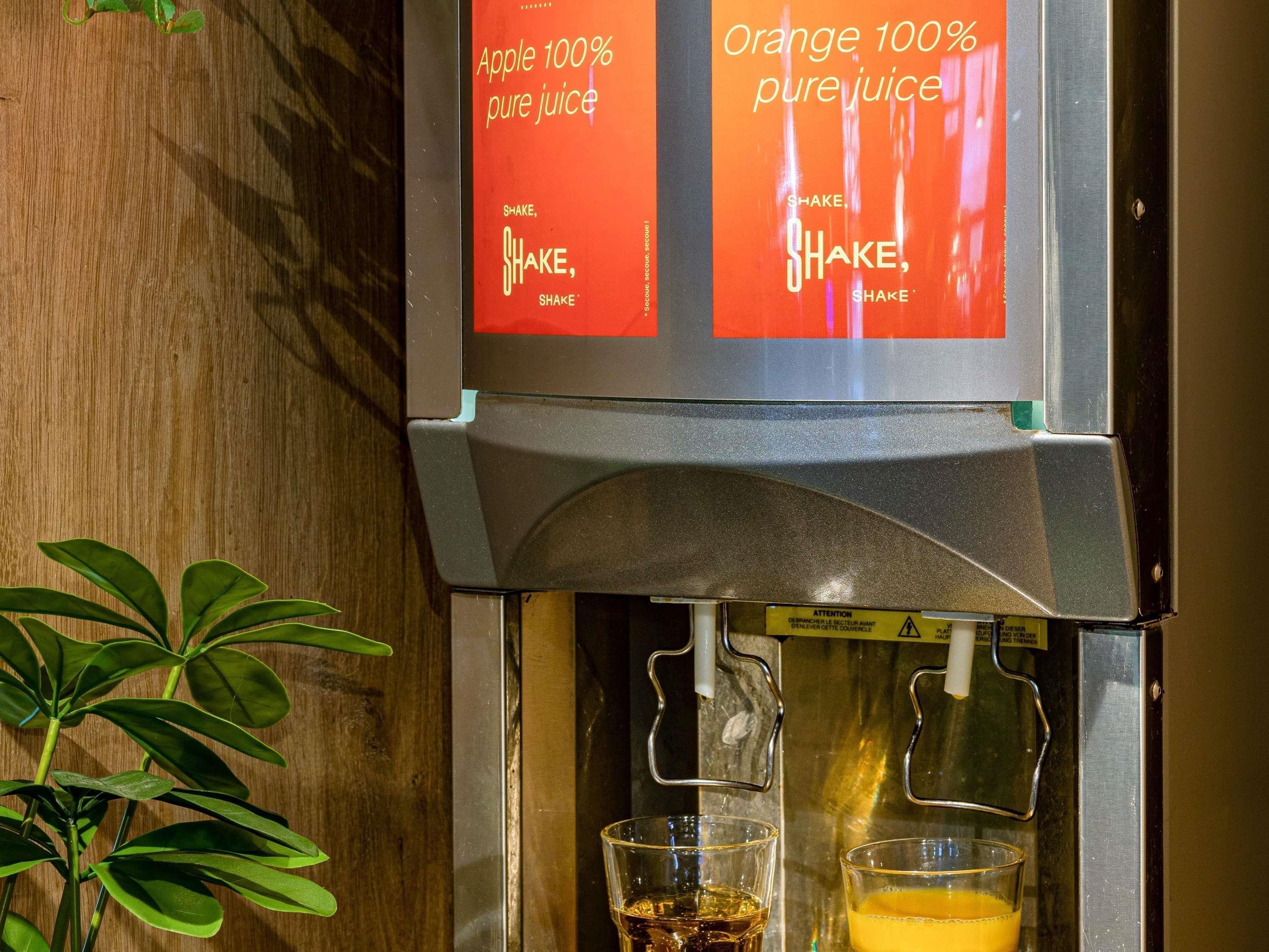 A juice dispenser with labels for Apple and Orange 100% pure juice.