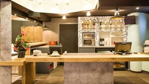 Une cuisine moderne dotée d’un îlot central, d’un four à micro-ondes, d’une machine à café et d’un coin bar avec des bouteilles.