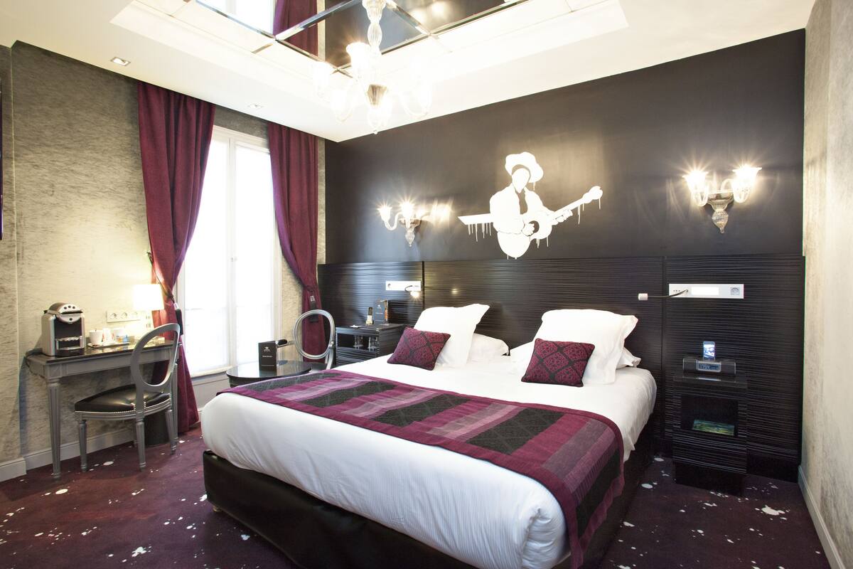 Ein modernes Hotelzimmer mit einem großen Bett, einem Schreibtisch und einem Stuhl.