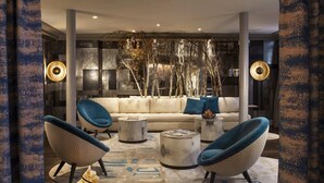 A modern living room with a sectional sofa, two armchairs, and a coffee table. - Hotel Therese (Paris)