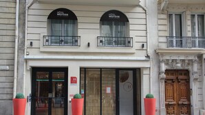 A hotel with a classic facade, large glass doors, and two balconies. - Hôtel Westside Arc de Triomphe (Paris)