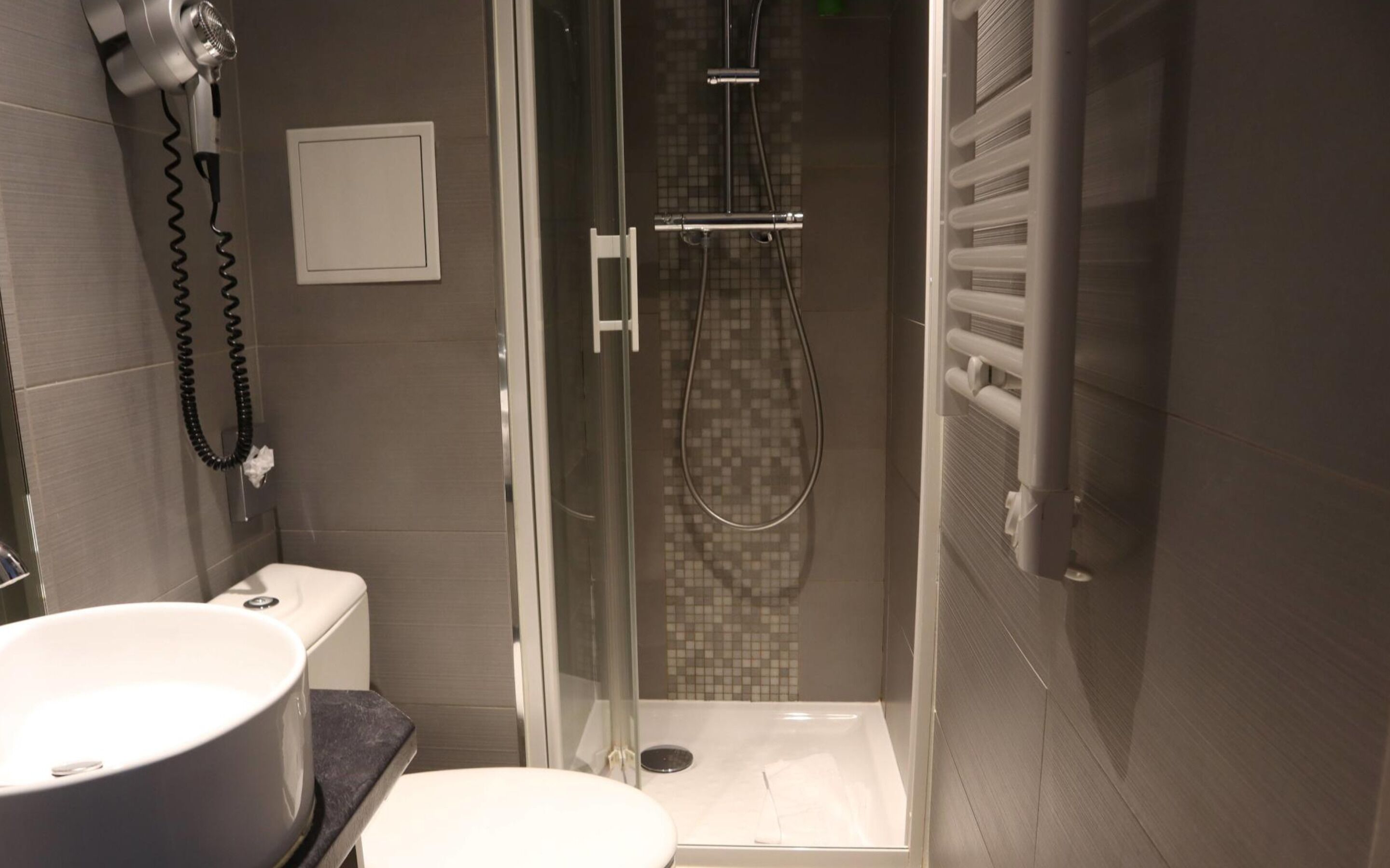 Un baño moderno con ducha de vidrio, inodoro y lavabo.