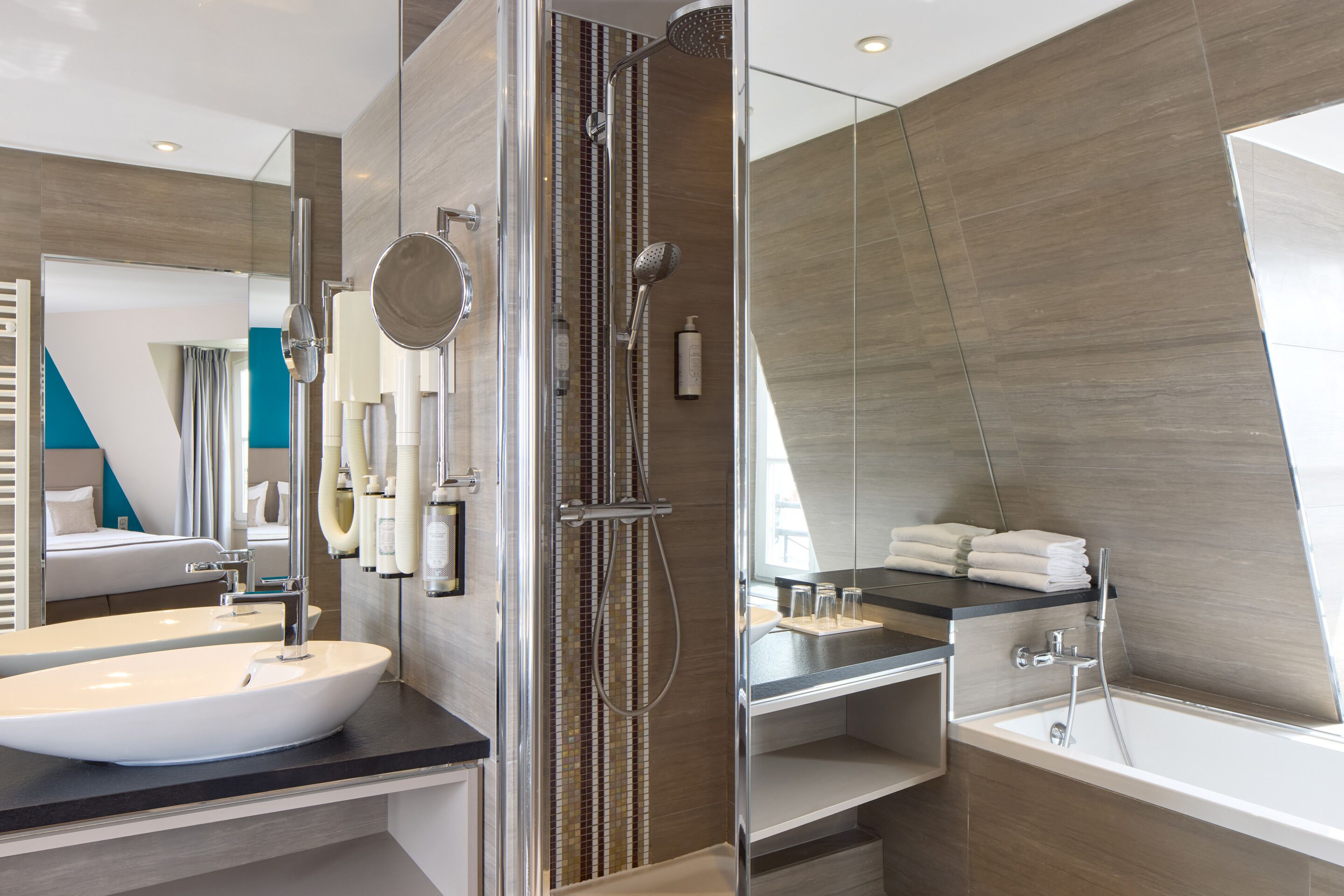 Ein modernes Badezimmer mit einem großen Waschbecken, einer Duschkabine aus Glas und einer Badewanne.