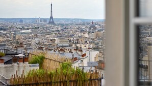 Blick auf den Eiffelturm von einer erhöhten Position, vermutlich von einem Hotelbalkon aus.