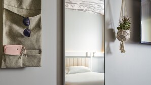 A modern bedroom with a large mirror, a bed, and a hanging macrame plant. - ibis Paris Nation Davout (Paris)