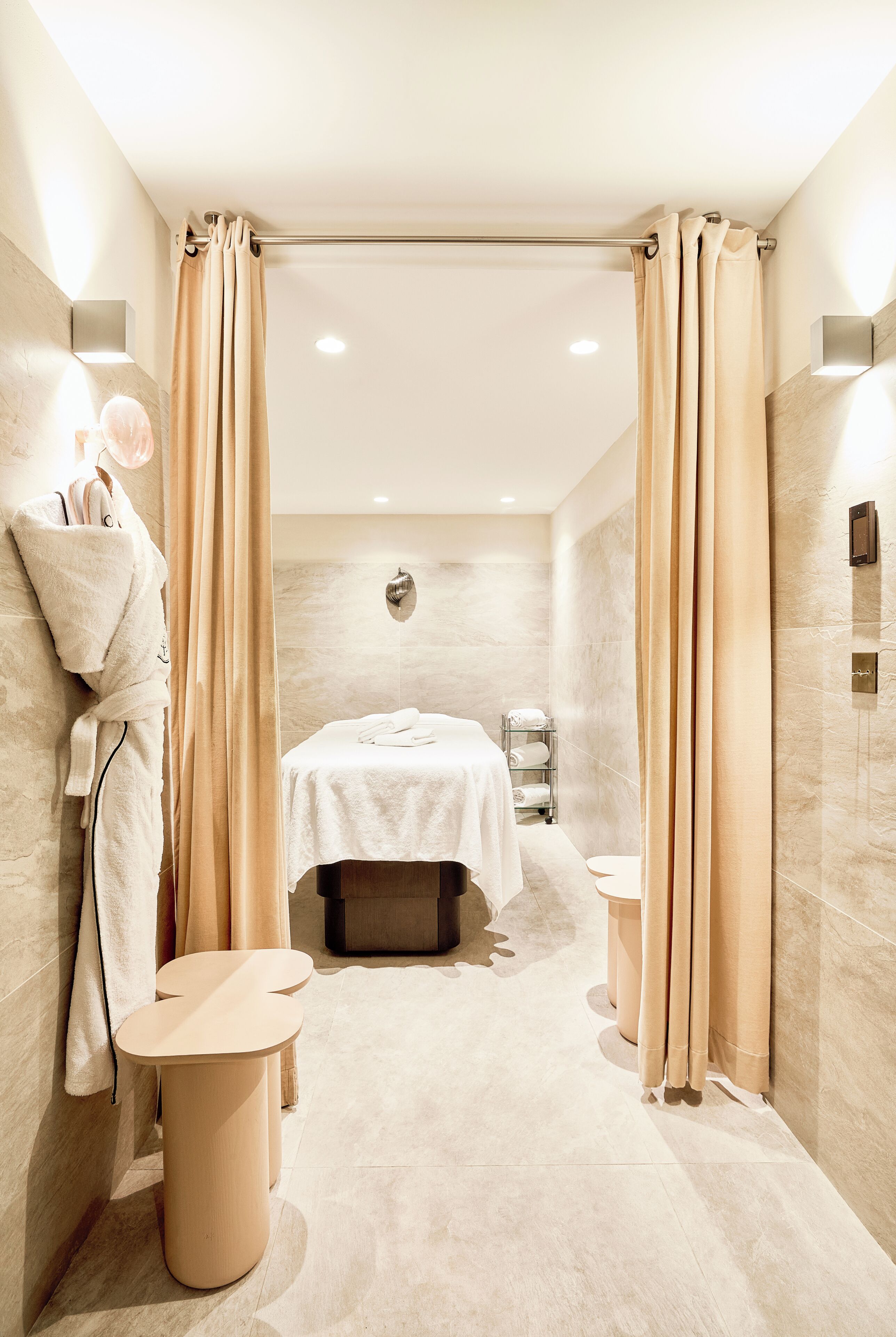 A modern bathroom with a bathtub, a towel rack, and a small table.