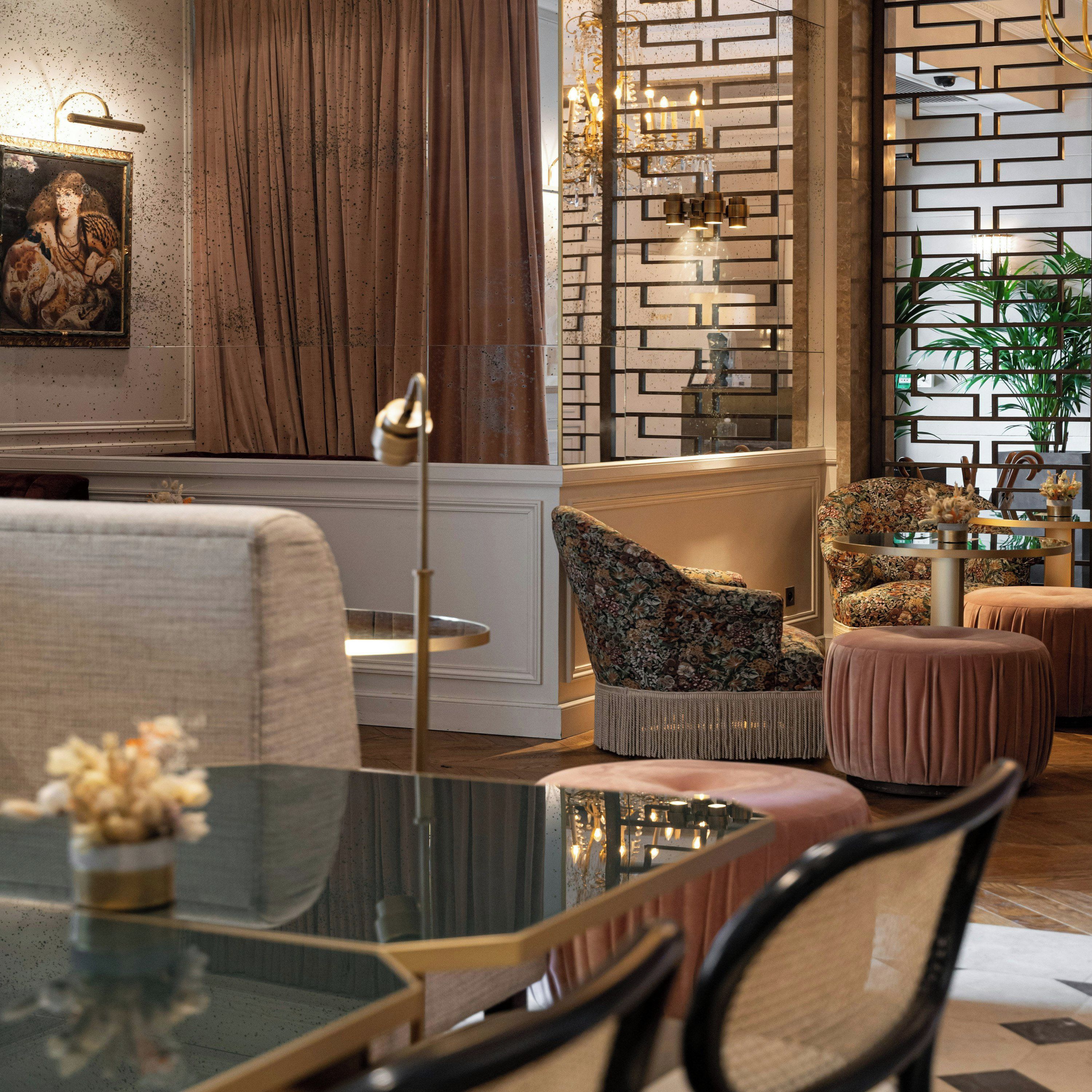Un salon moderne avec une table basse en verre, un canapé à motifs floraux et un panneau décoratif mural.