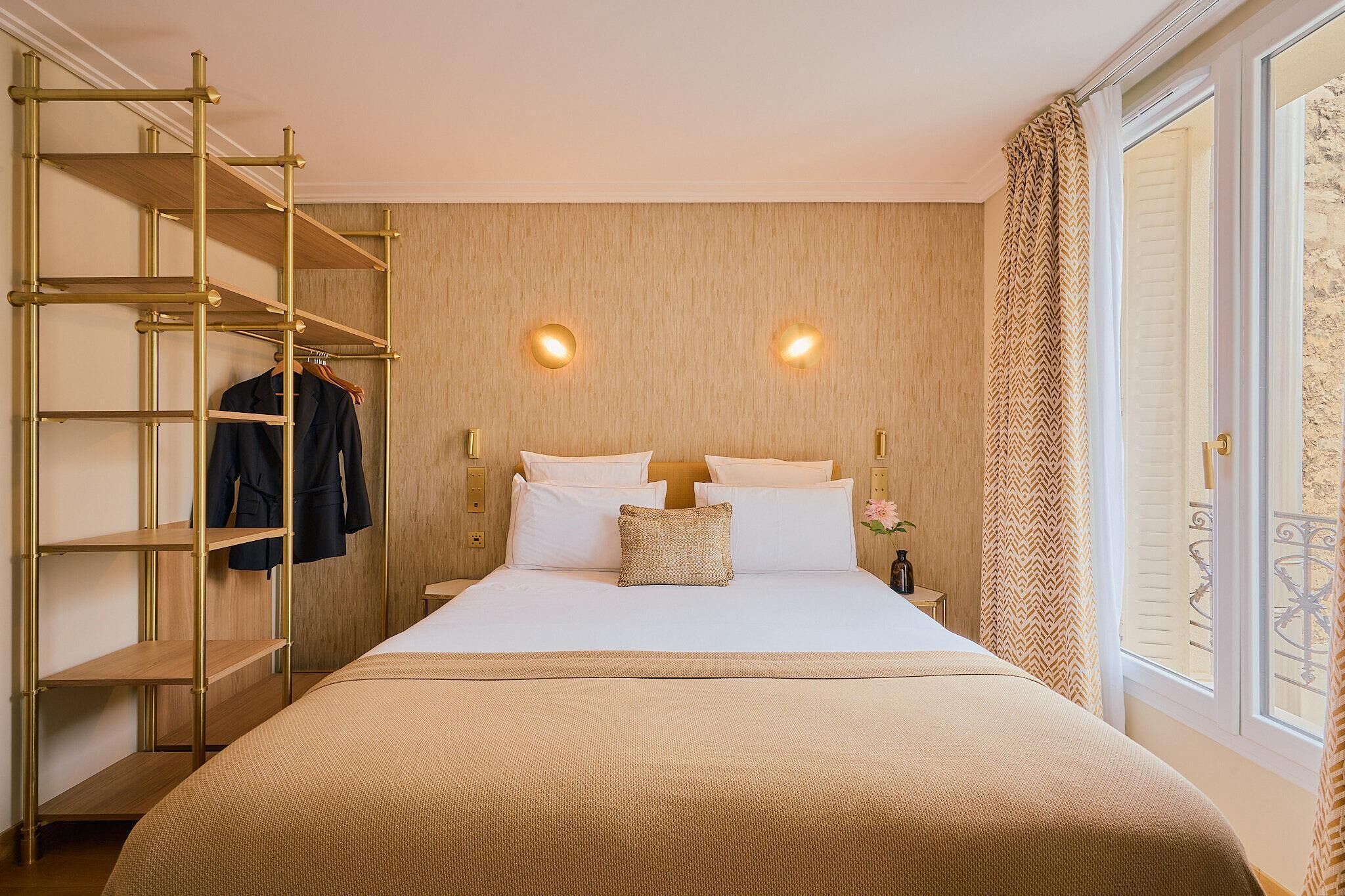 Ein Hotelzimmer mit einem Bett, einem Holzschrank und einem Fenster mit Vorhängen.