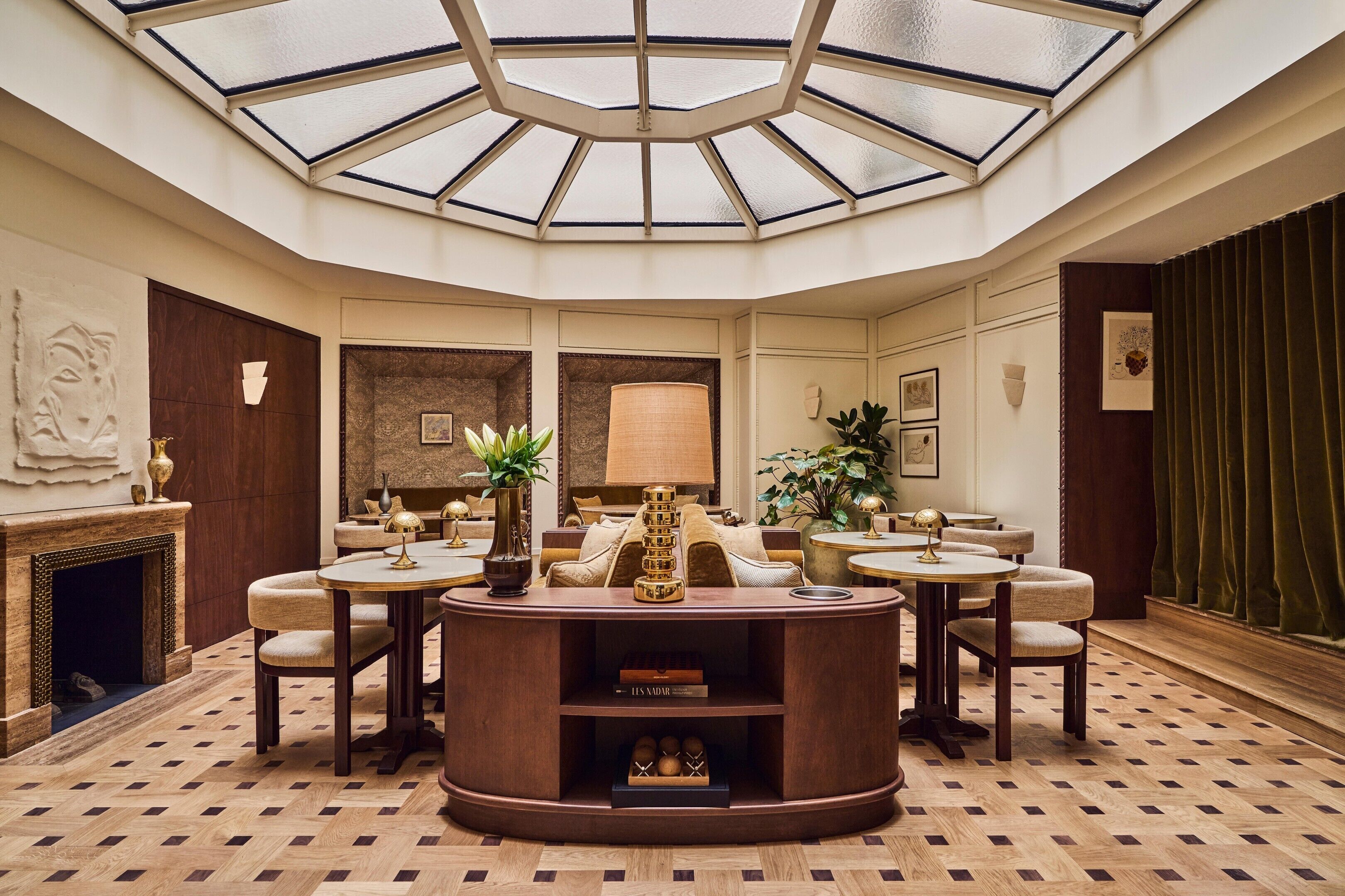 A spacious room with a central seating area, a fireplace, and a large skylight.