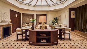 A spacious room with a central seating area, a fireplace, and a large skylight. - Hôtel Madison (Paris)