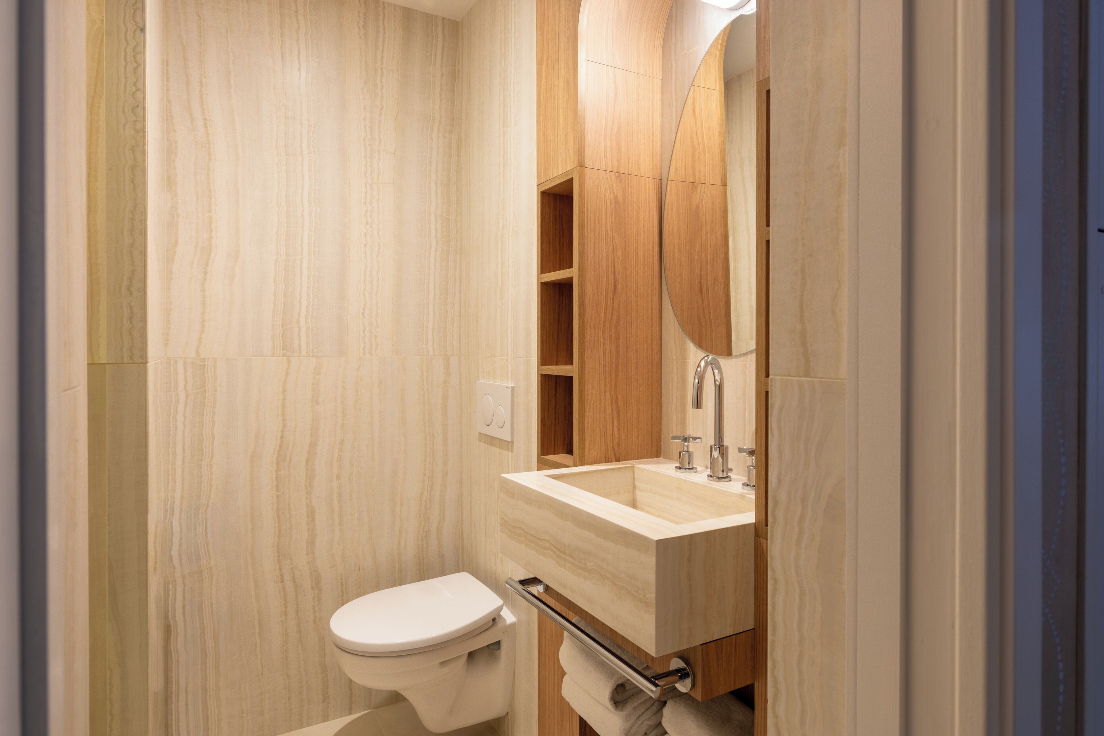 Un bagno moderno con il water, un lavandino e uno specchio.