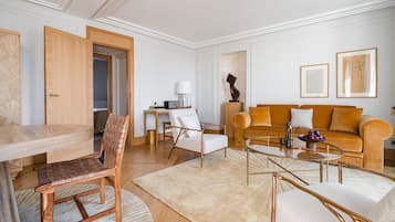 A modern living room with a wooden dining table, a sofa, and a coffee table.