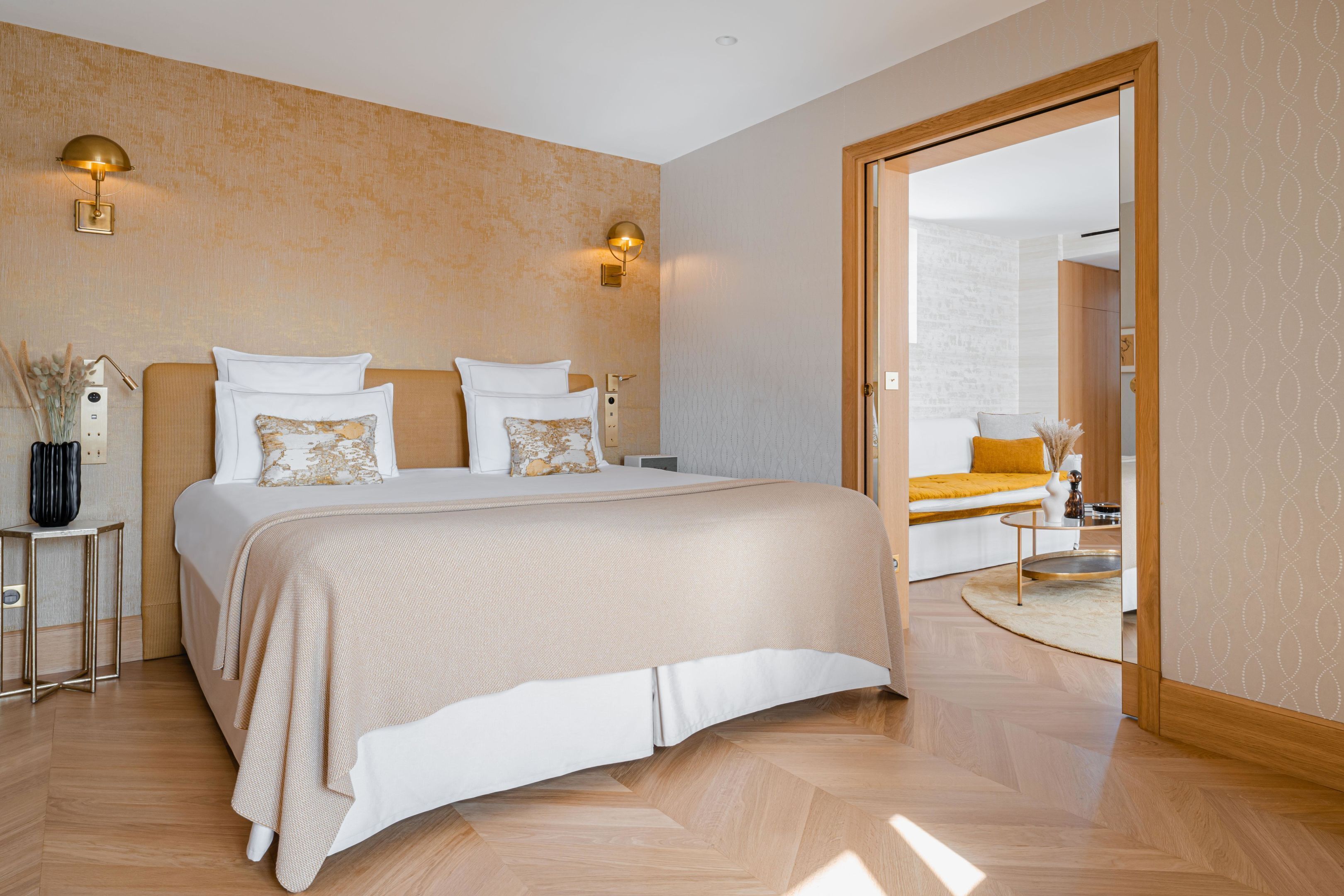 Quarto moderno com uma cama grande, duas luminárias de cabeceira e vista para uma varanda.